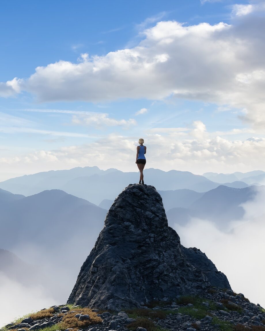 Woman standing on top of a rocky mountain